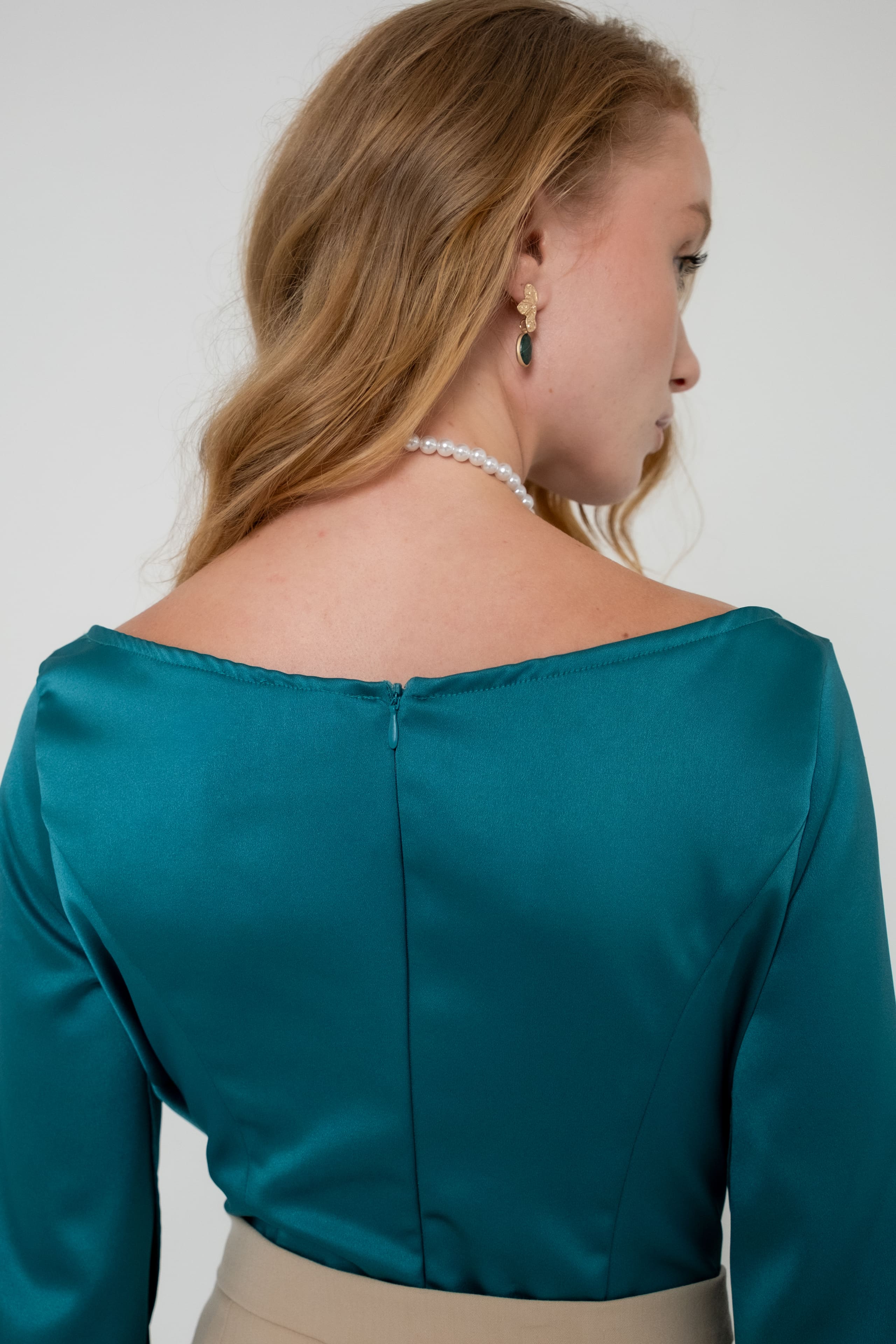 Mulher em vestido de cetim azul céu num jardim